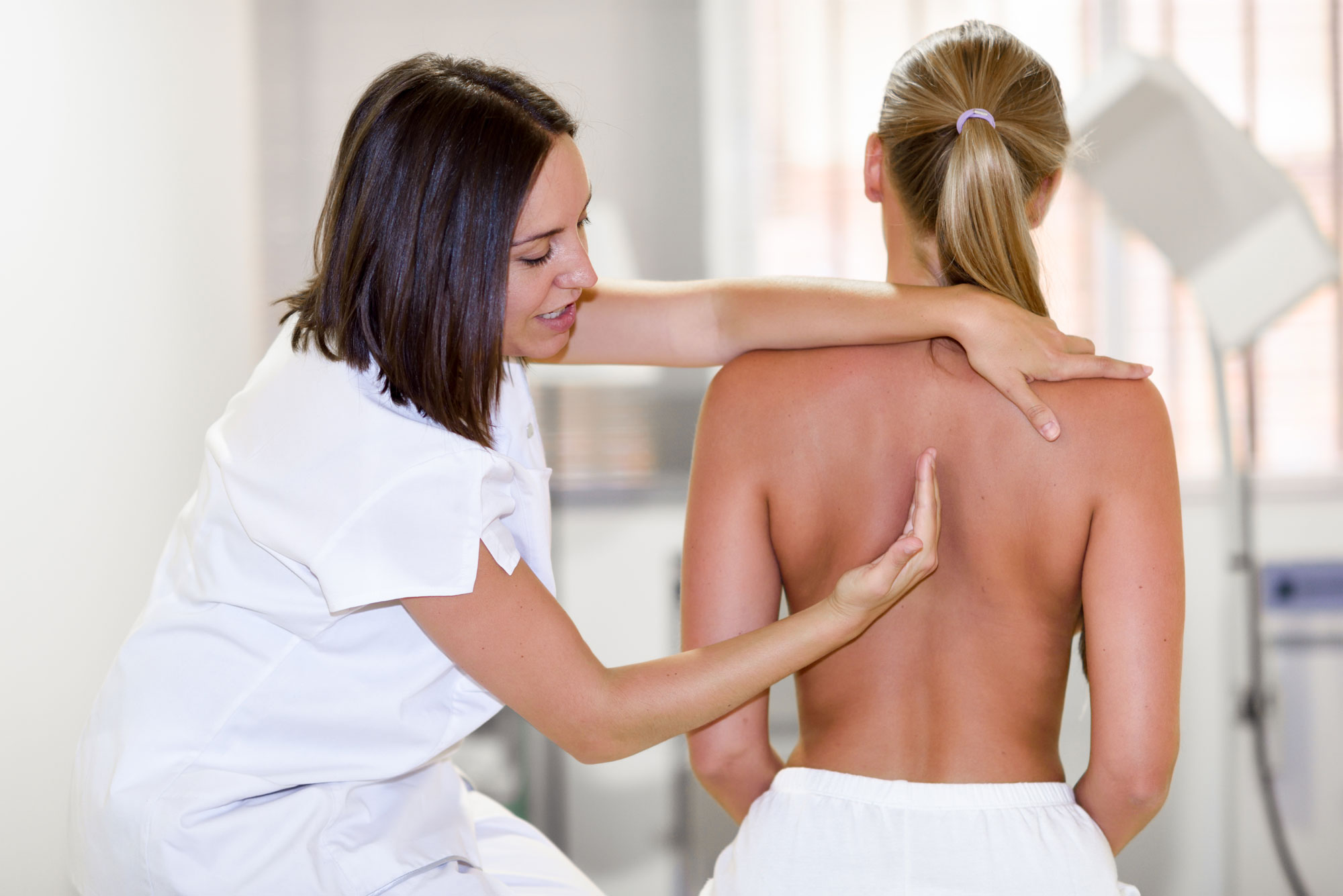 Chiropractor treating a patient in a clinic room